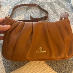 Soft pleated leather crossbody bag by Michael Kors. Crafted from smooth genuine leather in a rich brown tone. Features a chic pleated design, adjustab