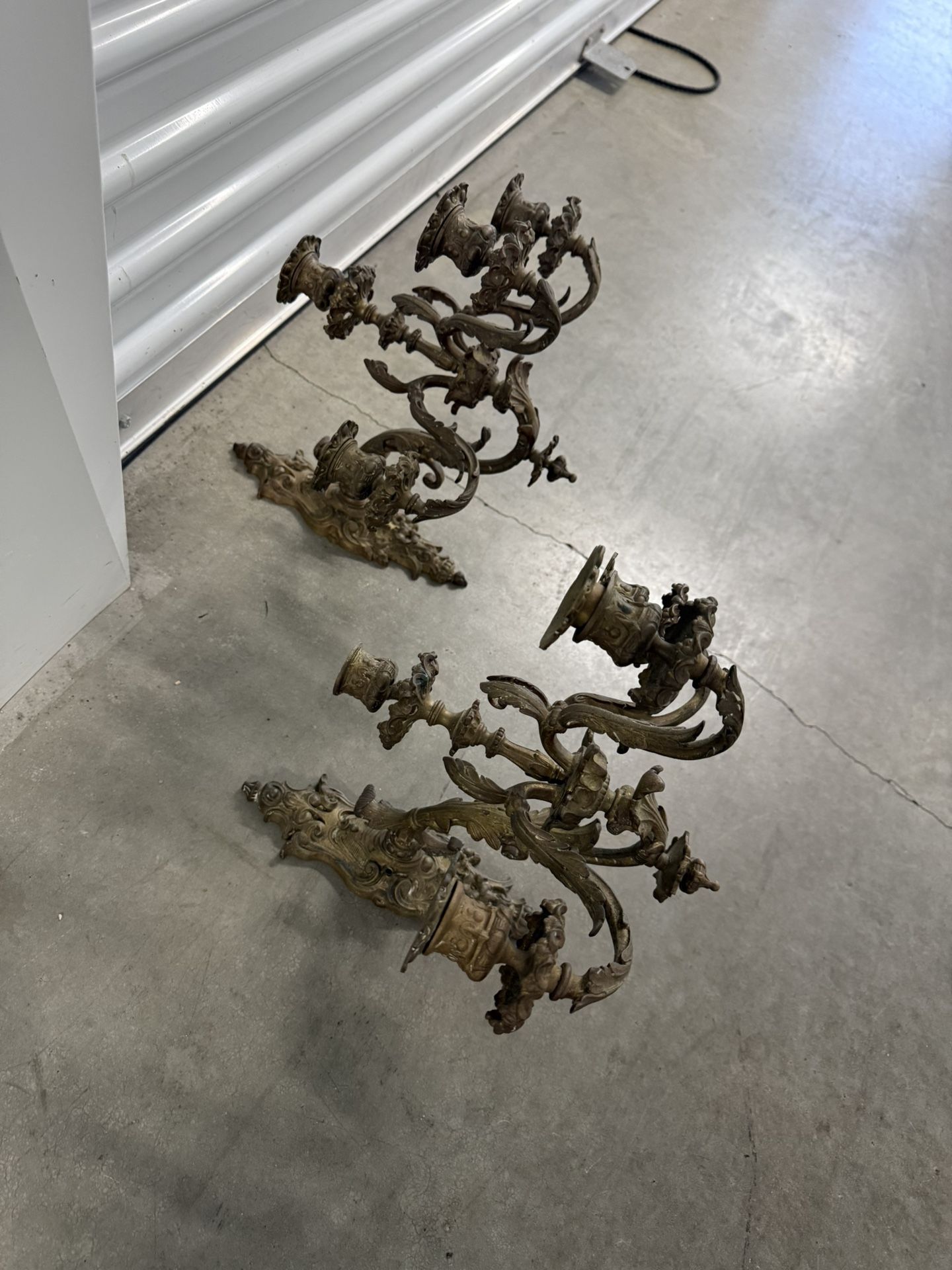 Ornate antique French-style brass wall sconces with multiple candle arms. Wall sconces have been used for centuries to provide ambient lighting, evolv