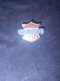 vintage Harley-Davidson "Motor Cycles" enamel lapel/hat pin featuring a stylized red and gold-trimmed shield design with a blue center bar.