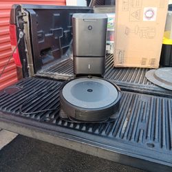 This item is an iRobot Roomba i3+ or i7+ robot vacuum cleaner with its Clean Base Automatic Dirt Disposal unit. 