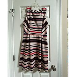 Elegant sleeveless dress by Gibson Latimer with a soft cream background and horizontal black, soft red, and subtle blue stripes. Flattering fit-and-fl