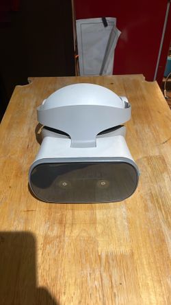 This item is a Lenovo Mirage Solo VR Headset, featuring a prominent black front visor with dual camera sensors for https://offerup.com/redirect/?o=dHJ