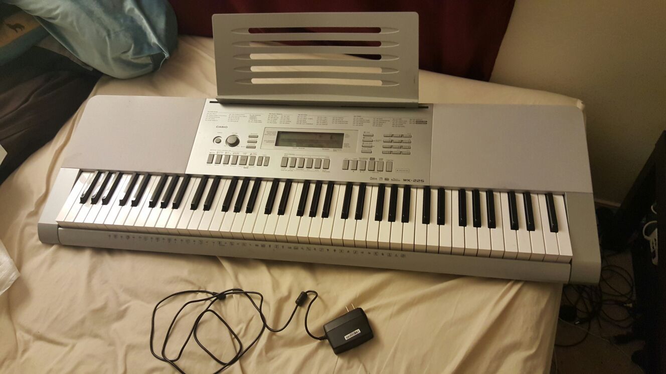 Casio electronic keyboard WK-225 with stand and sheet music