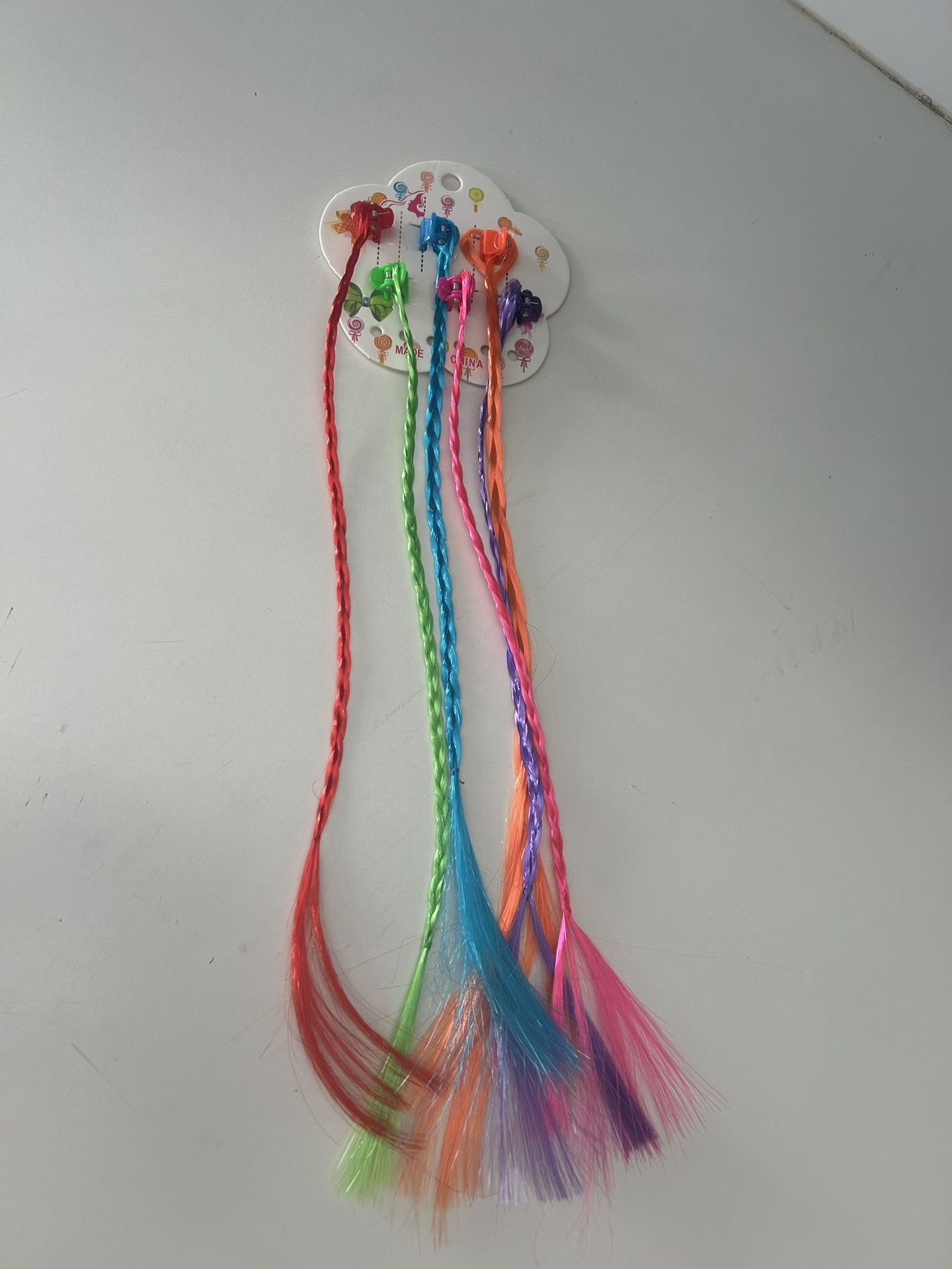 set of colorful, braided hair extensions with attached beads.