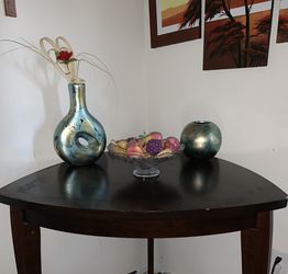 Table, 2 bar chairs, stone fruit bowl, and art pictures.