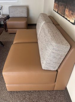 Comfortable two-seater sofas with brown leather cushions and fabric backrests.