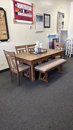 Dining table with extensions on the end with 4 chairs and bench