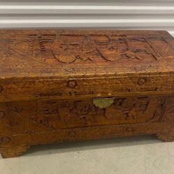 Antique Chinese carved camphor wood chest with intricate figural and scenic carvings.