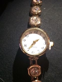 Gold alloy bracelet with watch charm that can be interchanged with different pieces to suit your mood