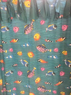 Shower curtain with hooks and yellow ceramic bathroom accessories.