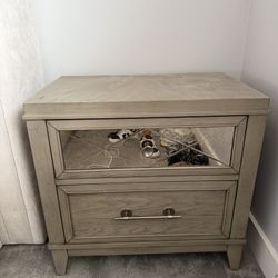 Selling a matching set of 2 nightstands in a neutral gray-washed wood finish. 	•	Each piece has 2 drawers (one with a mirrored front for a modern touc