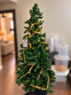 Artificial prelit pine Christmas tree includes lights and pre-wrapped gold tinsel