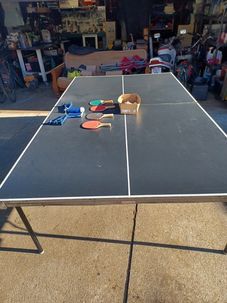 ping pong table.with 4 paddles and balls.