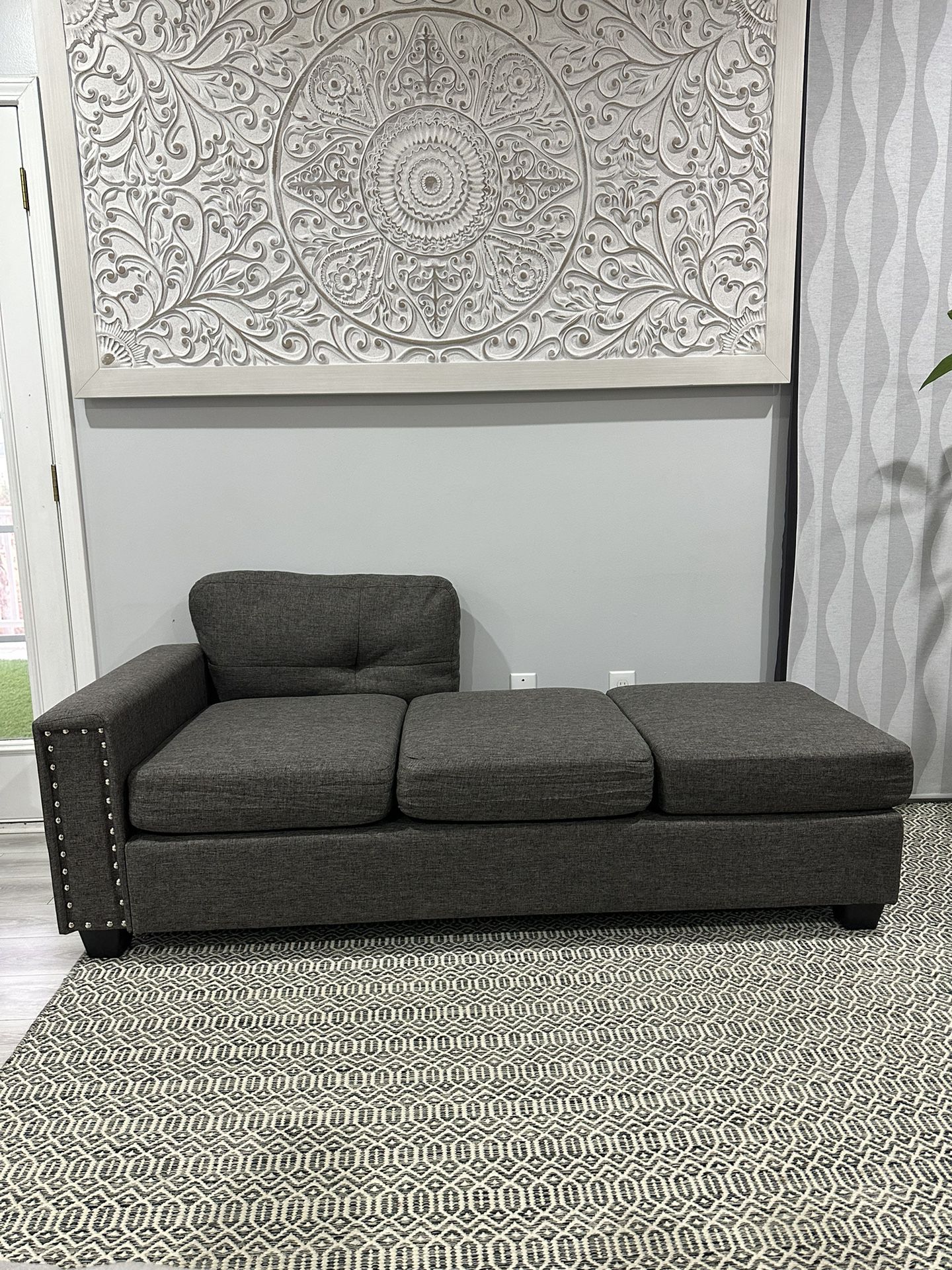 New Upholstered gray sofa with missing back and pillow. 74 inches long.