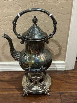 Silver ornate teapot with silver stand