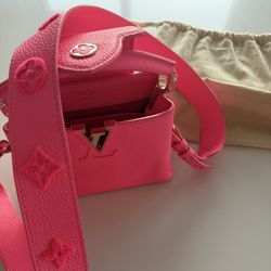Louis Vuitton Capucines Mini in hot / neon pink Taurillon leather with an embroidered strap.