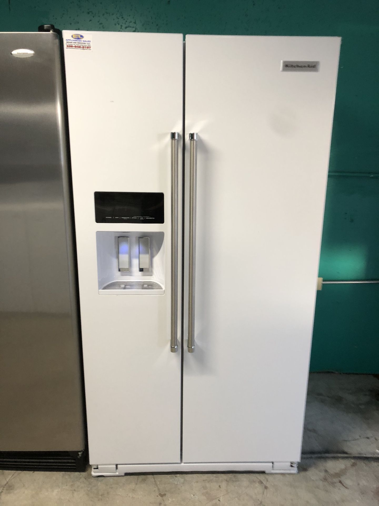 A white Kitchen Aide side by side refrigerator