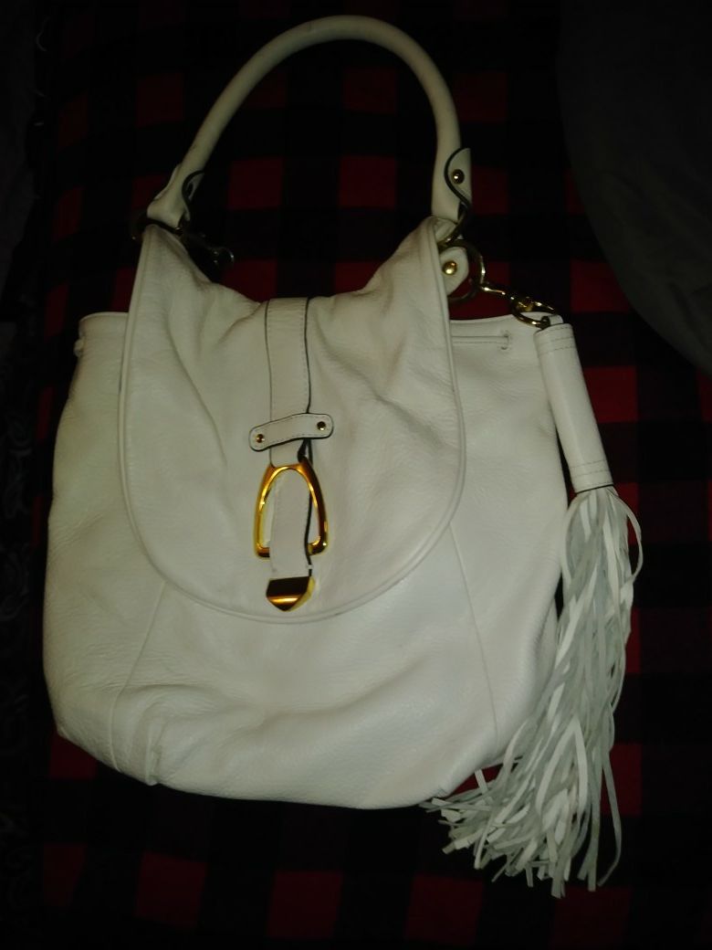 Super cute gently used white leather purse with removable tassle. No damage at all. Like new. Theres a couple little pen marks inside but thats it.