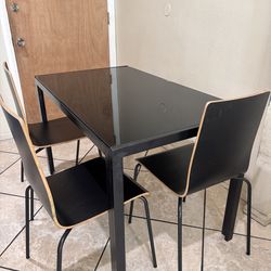 Black glass dining table with chairs