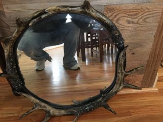 Mirror with a set of deer horns arranged around them