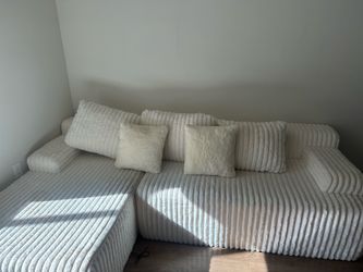 $200 tv and sofa bundle. cream boneless sofa with chaise and 65 inch Roku tv