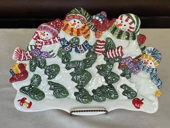 Decorative ceramic holiday Christmas serving platter featuring a dimensional snowman and pine design.