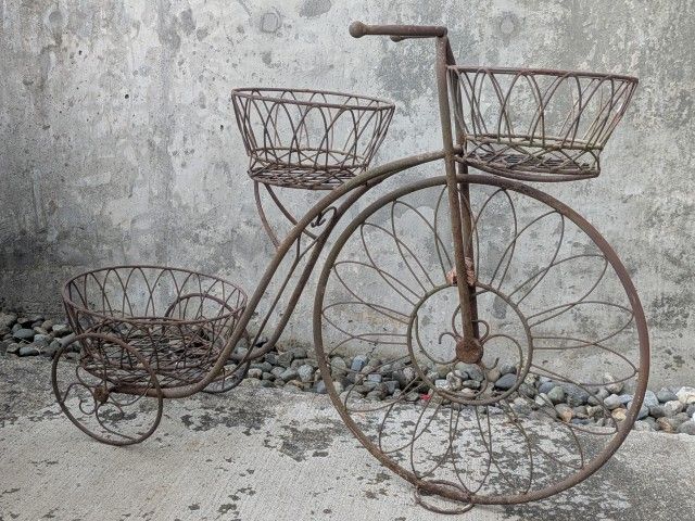Vintage metal art plant holder shaped like an old fashioned bicycle. About 3 feet long by 2 feet tall. Holds 3 plant containers. Adorable.