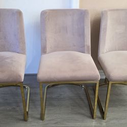 Three pink velvet and gold metal kitchen table chairs