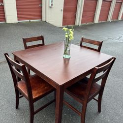 Red square wooden table and four chairs