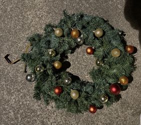 Decorative holiday wreath with ornaments and hanger