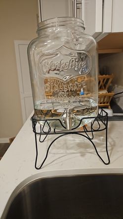 3 matching 2-gallon glass beverage dispensers with metal stands and stainless steel spigots.