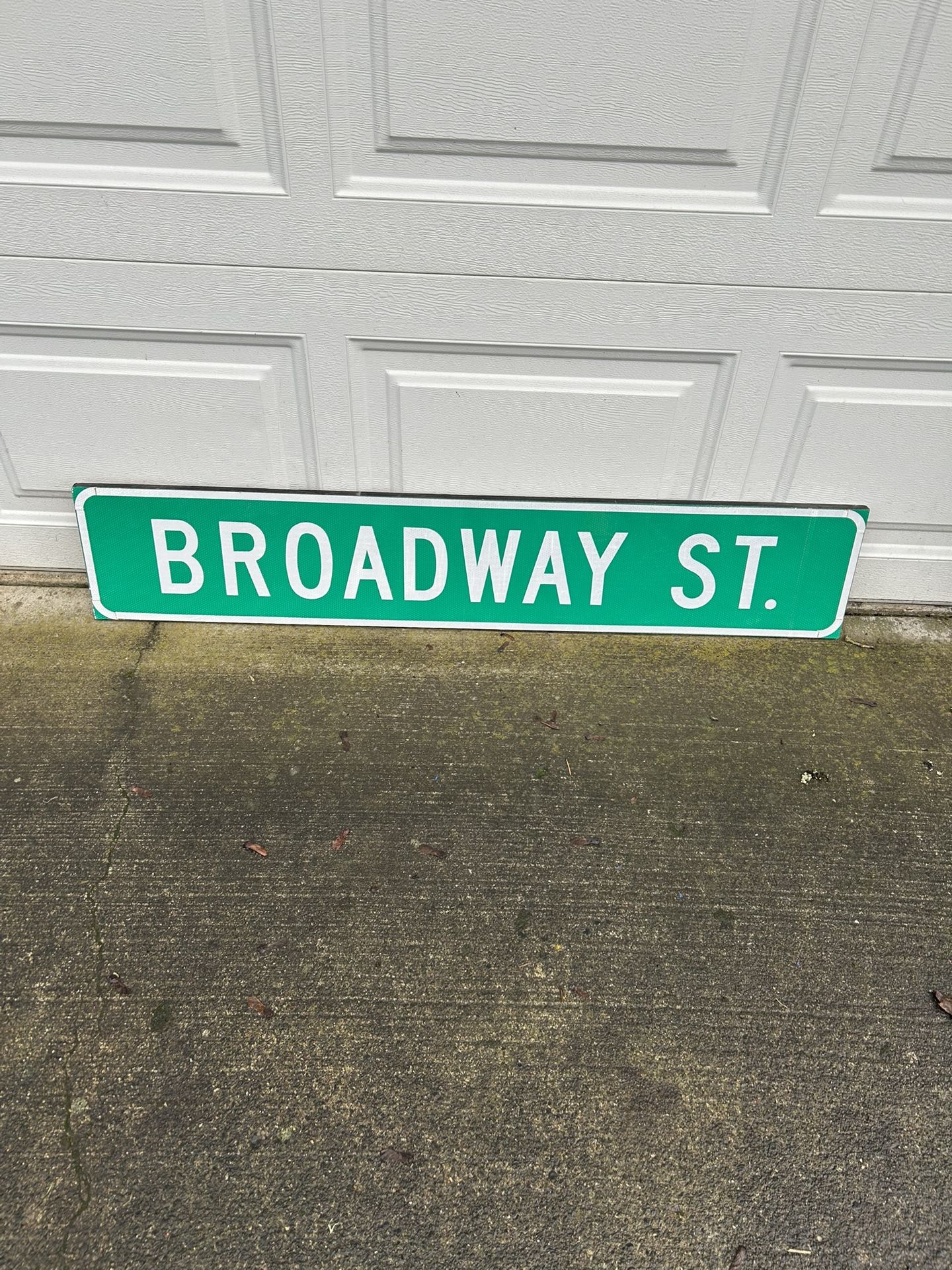 Broadway St. Road sign in great condition. Measure is 48 inches across and 6 inches in height. Made of reflective material on a plywood backing. Would
