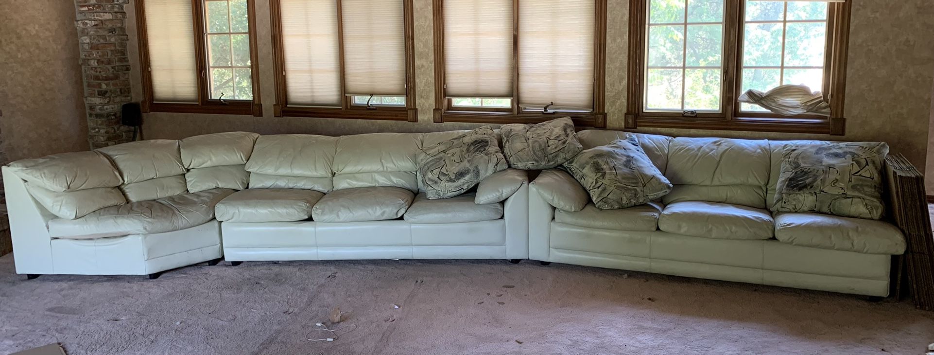 A large three-piece leather couch with queen size bed