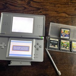 silver Nintendo Ds with 4 games a game case