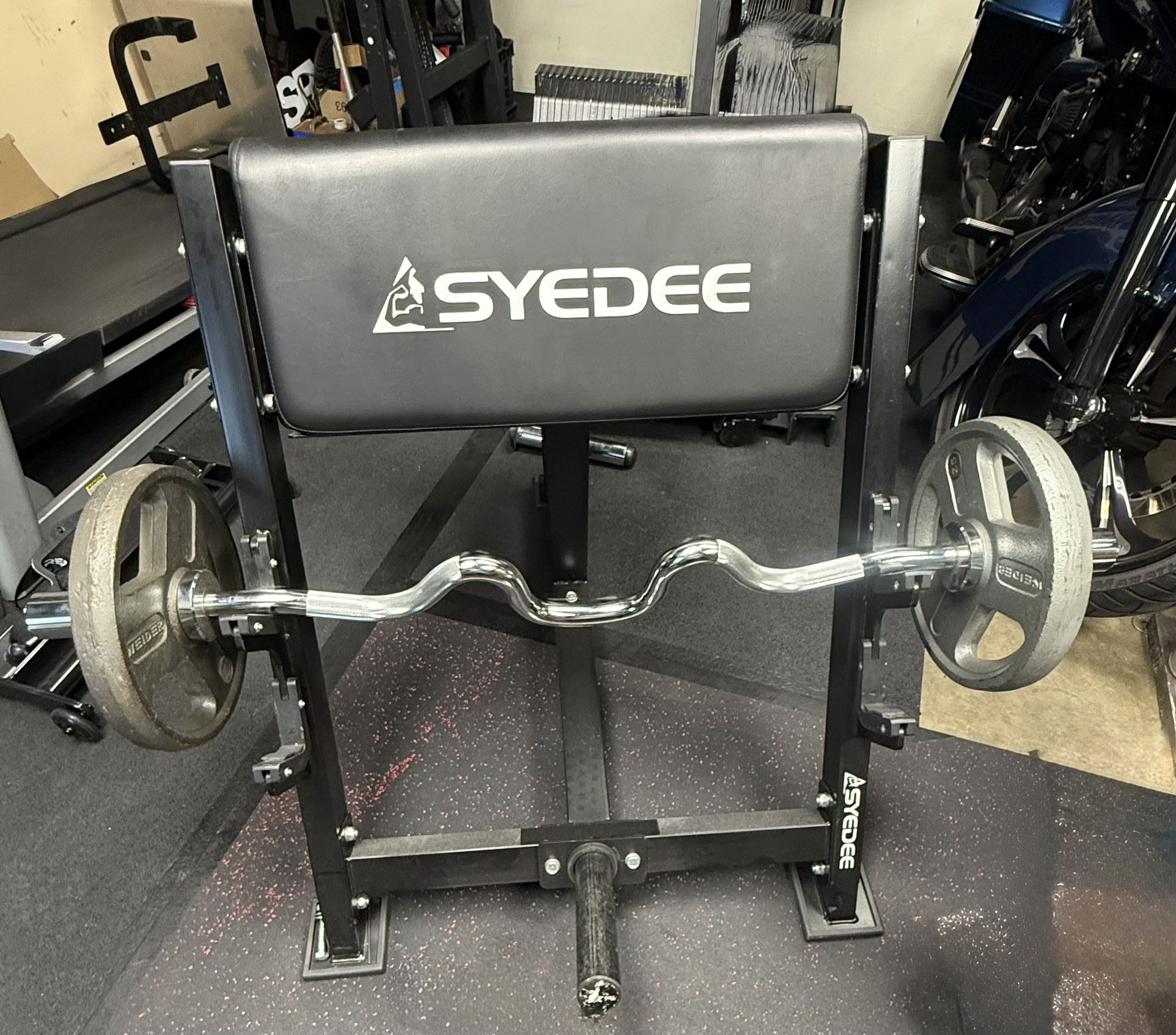 Curl bench with curl bar and weights.