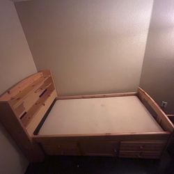 single wooden bed frame with drawers for storing clothes