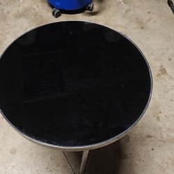 Black glass side table with a polished metal base. S
