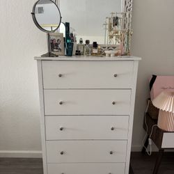Tall white dresser with a decorative framed mirror