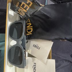 These are Fendi sunglasses with a gray frame and gold logo detailing.