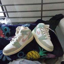 This is a Nike Air Jordan 1 Mid "Pink Oxford" sneaker in white, green, and pink leather