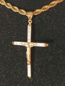 10 karat solid Gold Cross it weighs 2.1 g and it's worth about $100 on a 14 karat gold-plated necklace