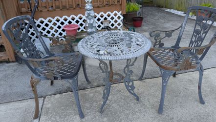 Cast iron patio/garden chairs and table set.  Solid construction