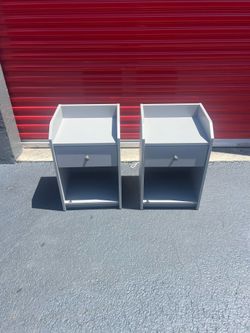 modern, light gray nightstands featuring an open top shelf, a single drawer, and a lower open cubby.