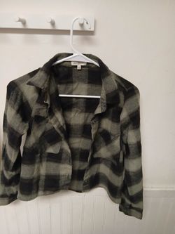 Free for All brand green and black plaid flannel shirt features a cropped cut and button-down front.