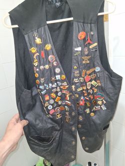 Leather motorcycle vest with vintage metals and pins
