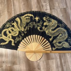 Chinese folding wall fan with a hand-painted golden dragon design.