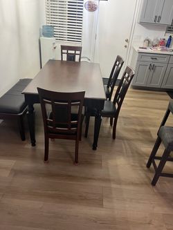 Wood dining table set with matching chairs in good condition.