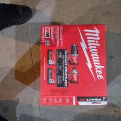 2 Milwaukee Tools Drill And Impact Driver Two Batteries And A Charger And A Bag