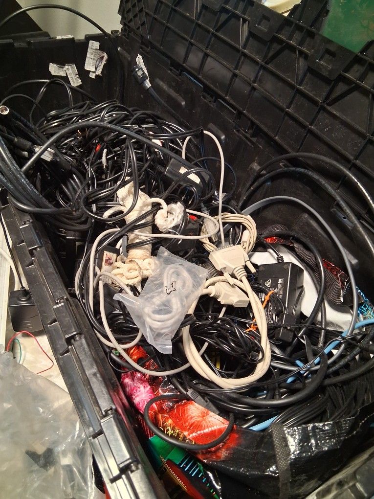 3 D Printer Parts With a Bin Full Of Cords And Chargers