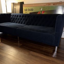 Blue button-tufted sofa.